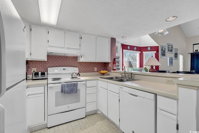 kitchen with sink, vaulted ceiling, white cabinetry, a textured ceiling, and white appliances