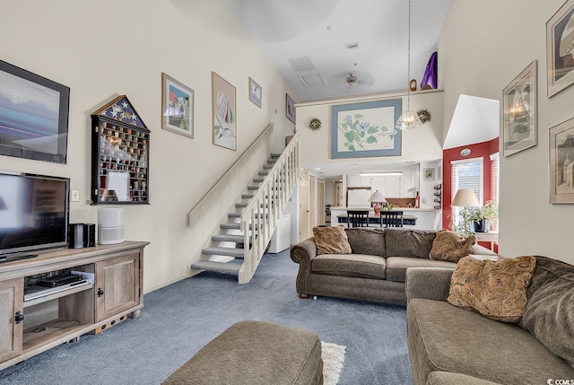 carpeted living room with high vaulted ceiling