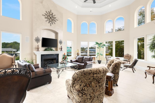 living room featuring ornamental molding, a fireplace, a towering ceiling, and light tile patterned floors