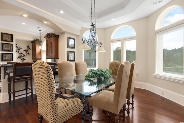 dining room with ornamental molding, dark hardwood / wood-style floors, and a tray ceiling