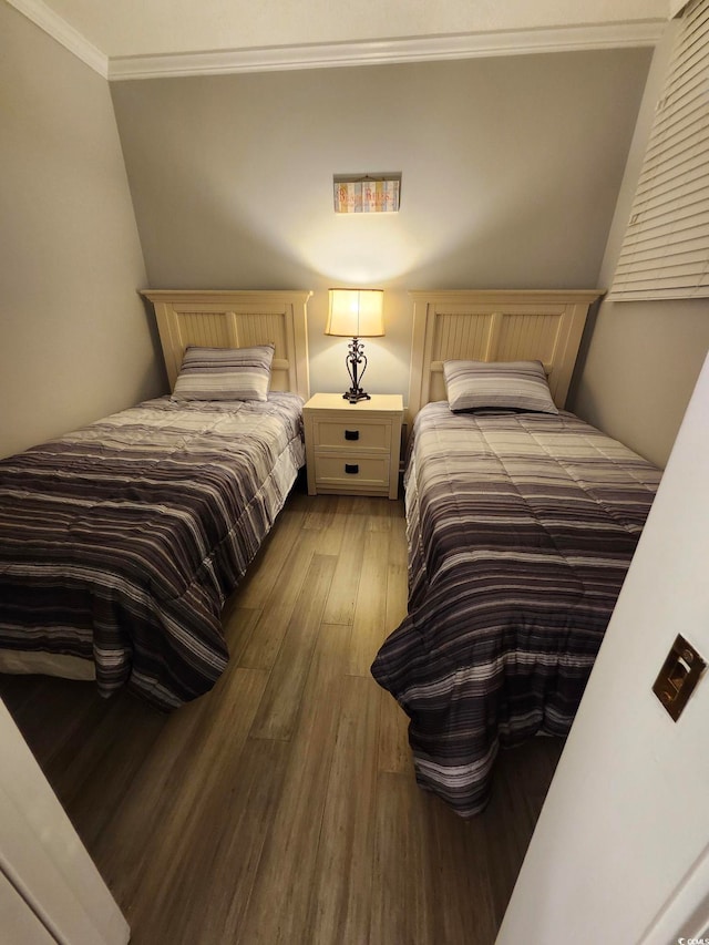 bedroom with ornamental molding and hardwood / wood-style floors