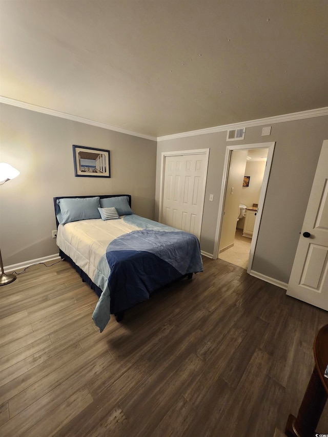 bedroom with a closet, ensuite bath, ornamental molding, and hardwood / wood-style floors