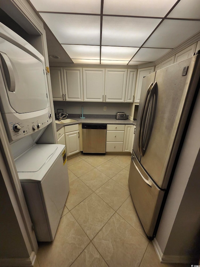 kitchen featuring cream cabinets, sink, light tile patterned flooring, a paneled ceiling, and stainless steel appliances