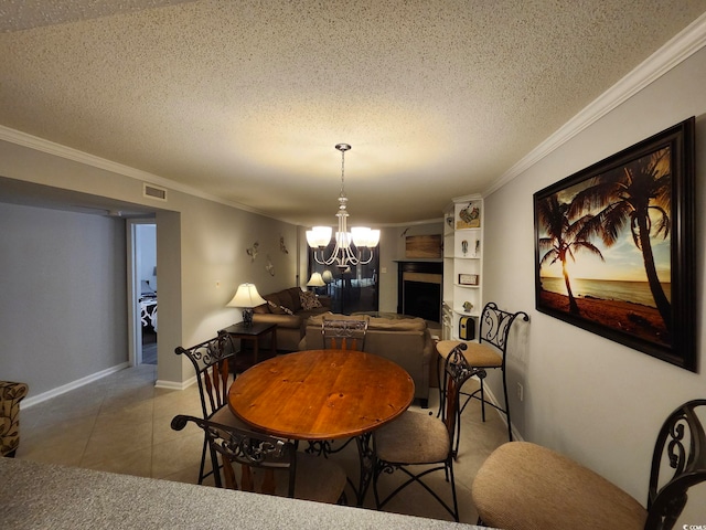 dining area with tile patterned floors, a textured ceiling, ornamental molding, and a chandelier