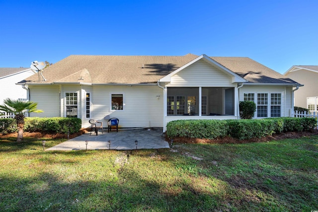 rear view of property with a patio, a lawn, and a sunroom