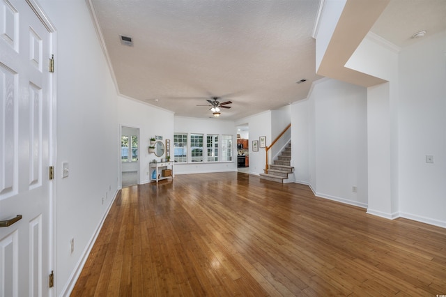 unfurnished living room featuring ornamental molding, hardwood / wood-style flooring, a textured ceiling, and ceiling fan