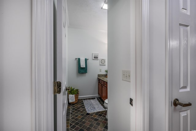 bathroom featuring vanity, crown molding, a textured ceiling, and toilet