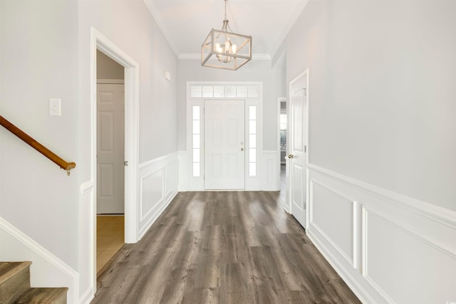 foyer entrance featuring an inviting chandelier, dark hardwood / wood-style flooring, and ornamental molding