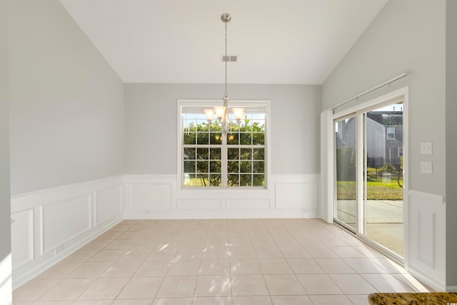 unfurnished dining area featuring a healthy amount of sunlight, vaulted ceiling, and light tile patterned floors