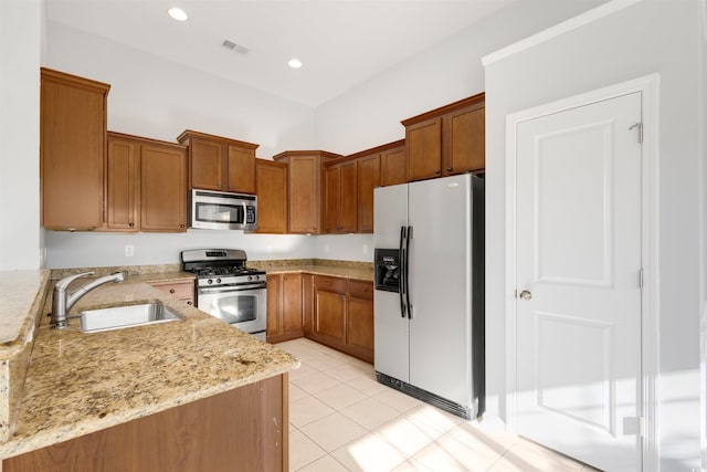 kitchen featuring light stone countertops, sink, light tile patterned floors, and stainless steel appliances