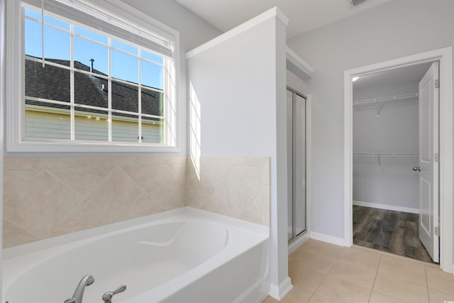 bathroom featuring independent shower and bath and tile patterned flooring