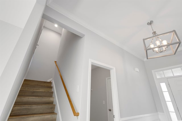 staircase featuring a chandelier and crown molding