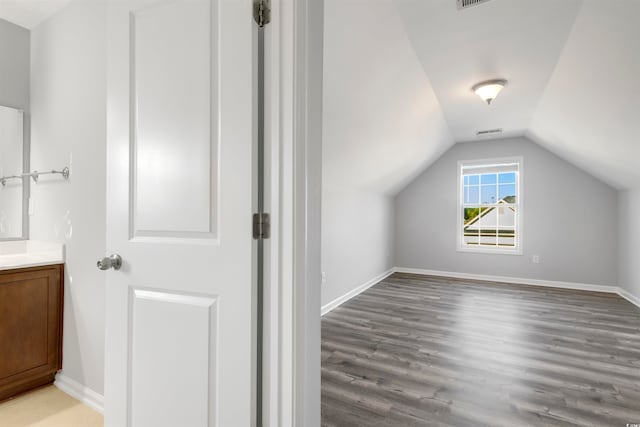 additional living space featuring wood-type flooring and vaulted ceiling