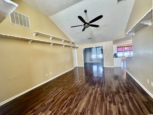 unfurnished living room with ceiling fan, a textured ceiling, lofted ceiling, and dark hardwood / wood-style floors