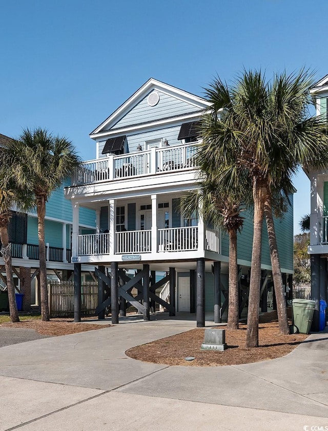 beach home with a balcony, a carport, and a porch