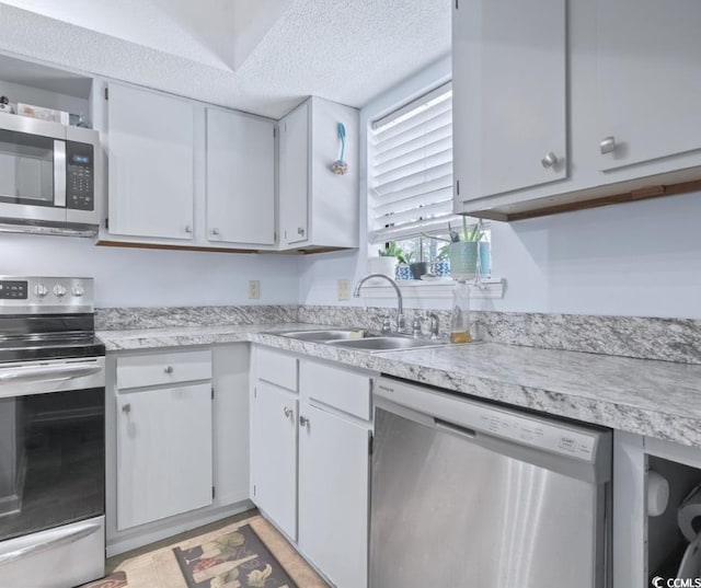 kitchen with sink, appliances with stainless steel finishes, and a textured ceiling