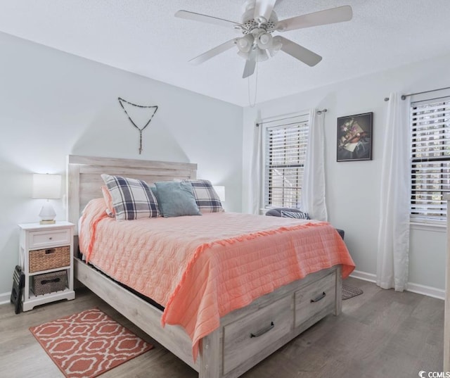 bedroom featuring multiple windows, hardwood / wood-style flooring, and a textured ceiling