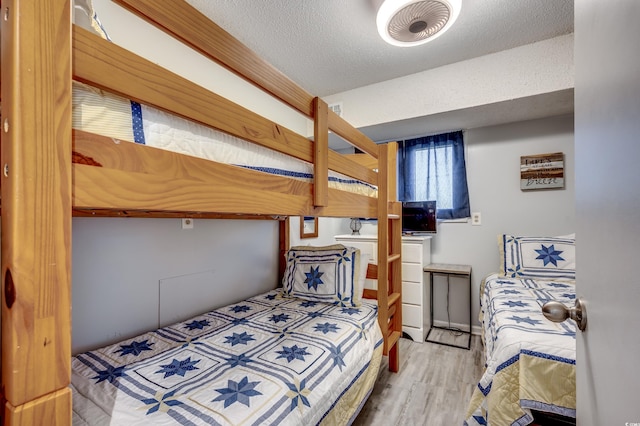 bedroom featuring wood-type flooring and a textured ceiling