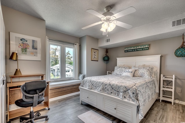 bedroom featuring a textured ceiling, hardwood / wood-style flooring, and ceiling fan