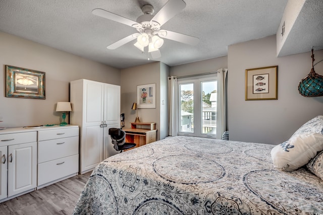 bedroom featuring a textured ceiling, light wood-type flooring, and ceiling fan