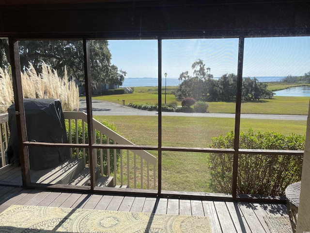 sunroom / solarium featuring a water view