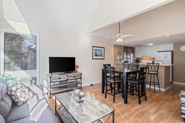 dining room with light hardwood / wood-style floors, vaulted ceiling, and ceiling fan