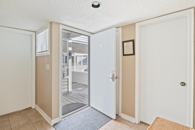 tiled foyer entrance featuring a textured ceiling