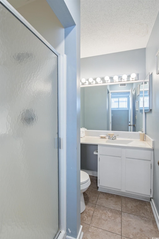 bathroom featuring tile patterned floors, an enclosed shower, vanity, a textured ceiling, and toilet