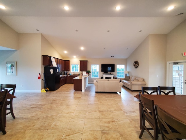 living room featuring high vaulted ceiling and light tile patterned floors