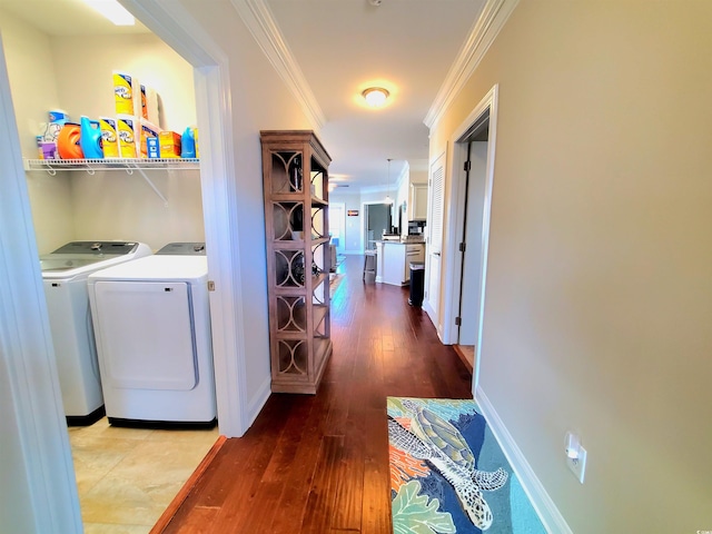 hallway featuring crown molding, washing machine and clothes dryer, and hardwood / wood-style flooring