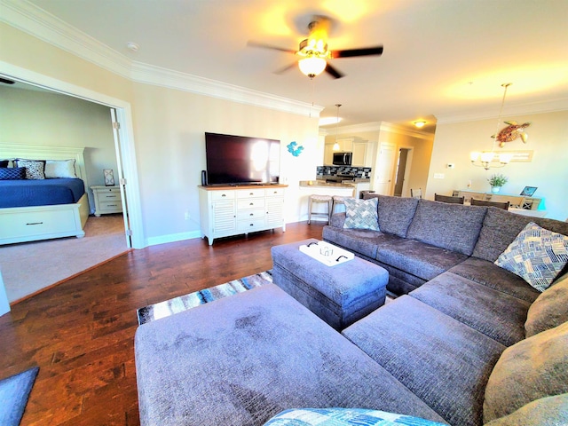 living room with dark wood-type flooring, crown molding, and ceiling fan