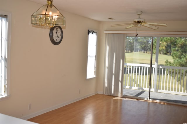 interior space with hardwood / wood-style flooring and ceiling fan with notable chandelier