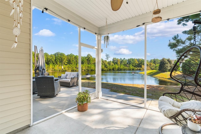 unfurnished sunroom featuring a water view and ceiling fan