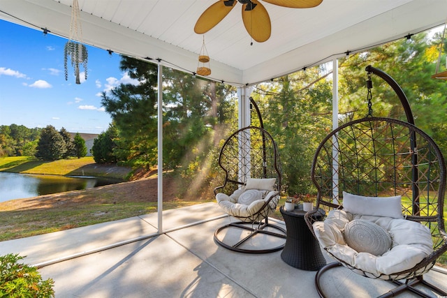 sunroom / solarium featuring a water view and ceiling fan