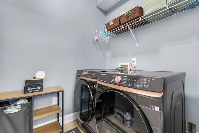 laundry room featuring wood-type flooring and separate washer and dryer