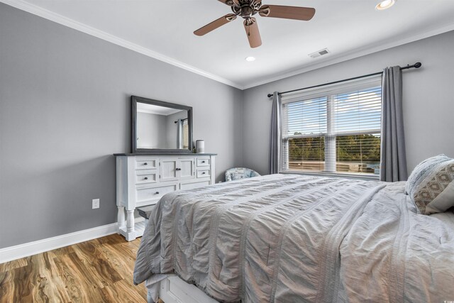 bedroom with crown molding, wood-type flooring, and ceiling fan