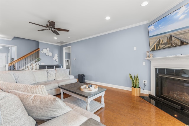 living room featuring crown molding, hardwood / wood-style flooring, and ceiling fan