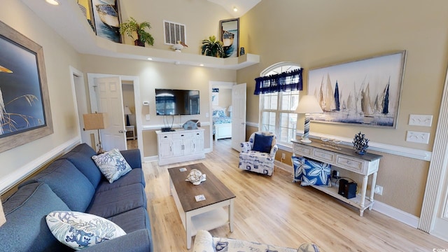 living room with a high ceiling and hardwood / wood-style flooring