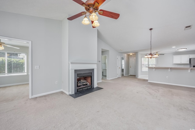 unfurnished living room featuring light carpet, ceiling fan, and vaulted ceiling