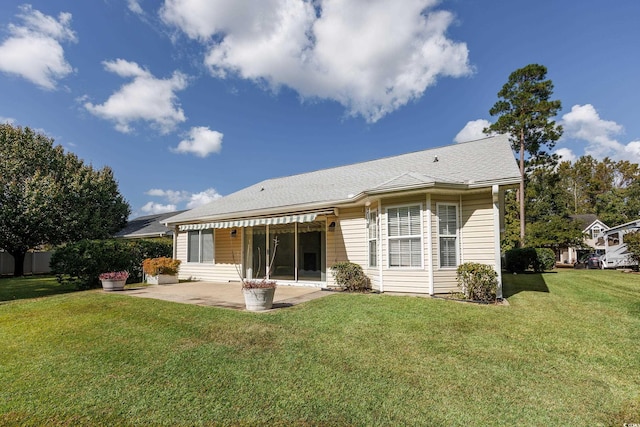 rear view of house with a patio and a lawn