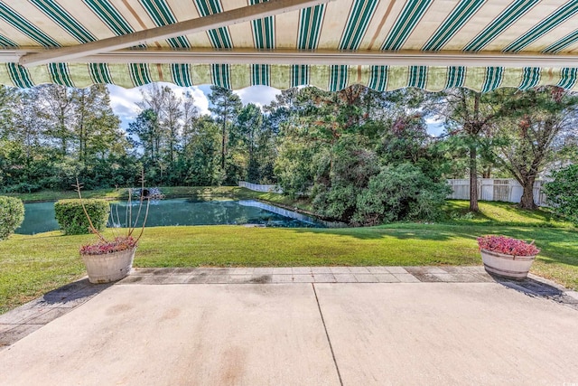 surrounding community featuring a patio, a yard, and a water view