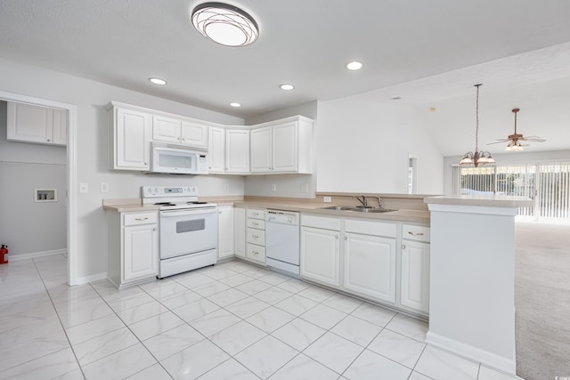 kitchen with white appliances, sink, kitchen peninsula, vaulted ceiling, and white cabinets