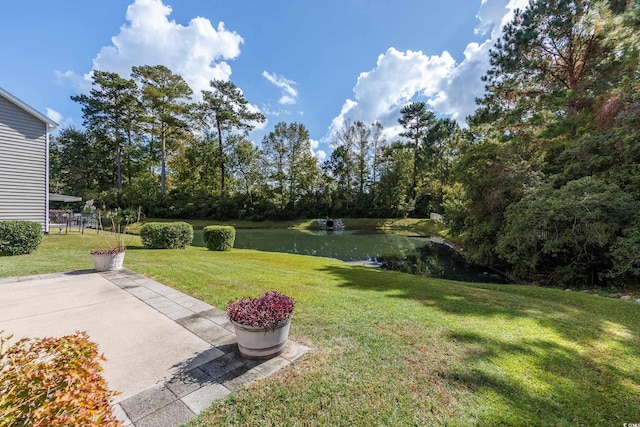 view of yard with a water view and a patio area