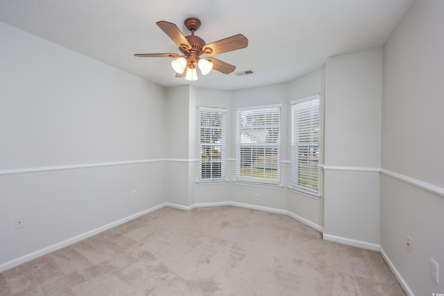 spare room featuring light carpet and ceiling fan