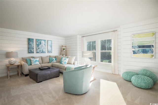 living room featuring light carpet and wooden walls