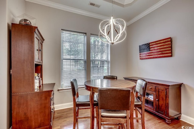 dining room with visible vents, ornamental molding, light wood-style floors, an inviting chandelier, and baseboards