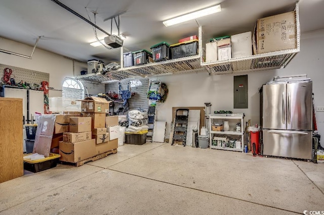 garage with electric panel, a garage door opener, and freestanding refrigerator