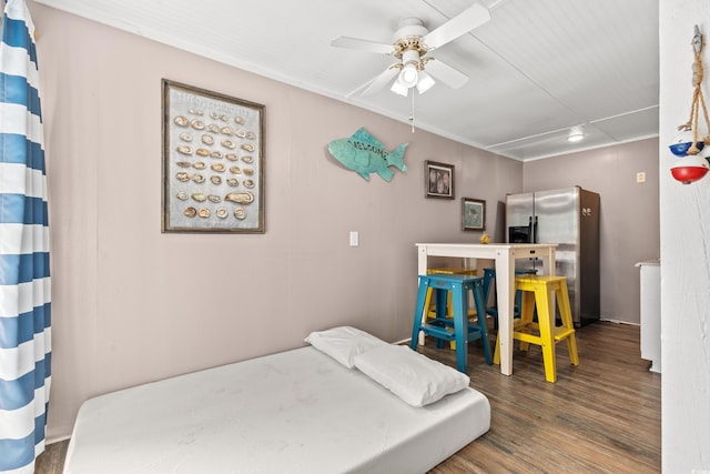 bedroom with ceiling fan, stainless steel fridge, and dark hardwood / wood-style flooring