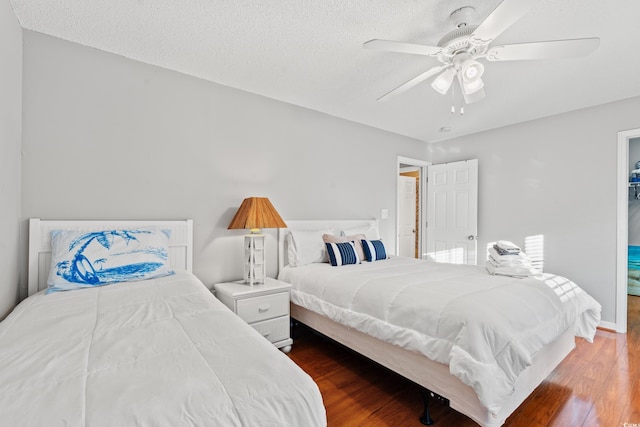 bedroom featuring hardwood / wood-style flooring, ceiling fan, and a textured ceiling