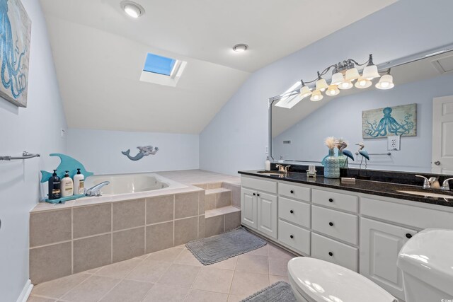 bathroom featuring tile patterned flooring, lofted ceiling with skylight, tiled tub, vanity, and toilet